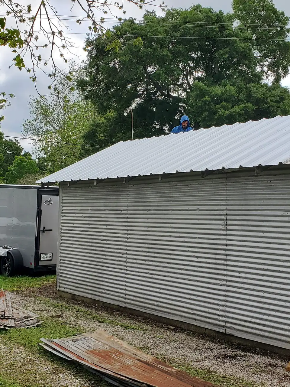 New corrugated metal roof on a barn with white ranch-rail fencing