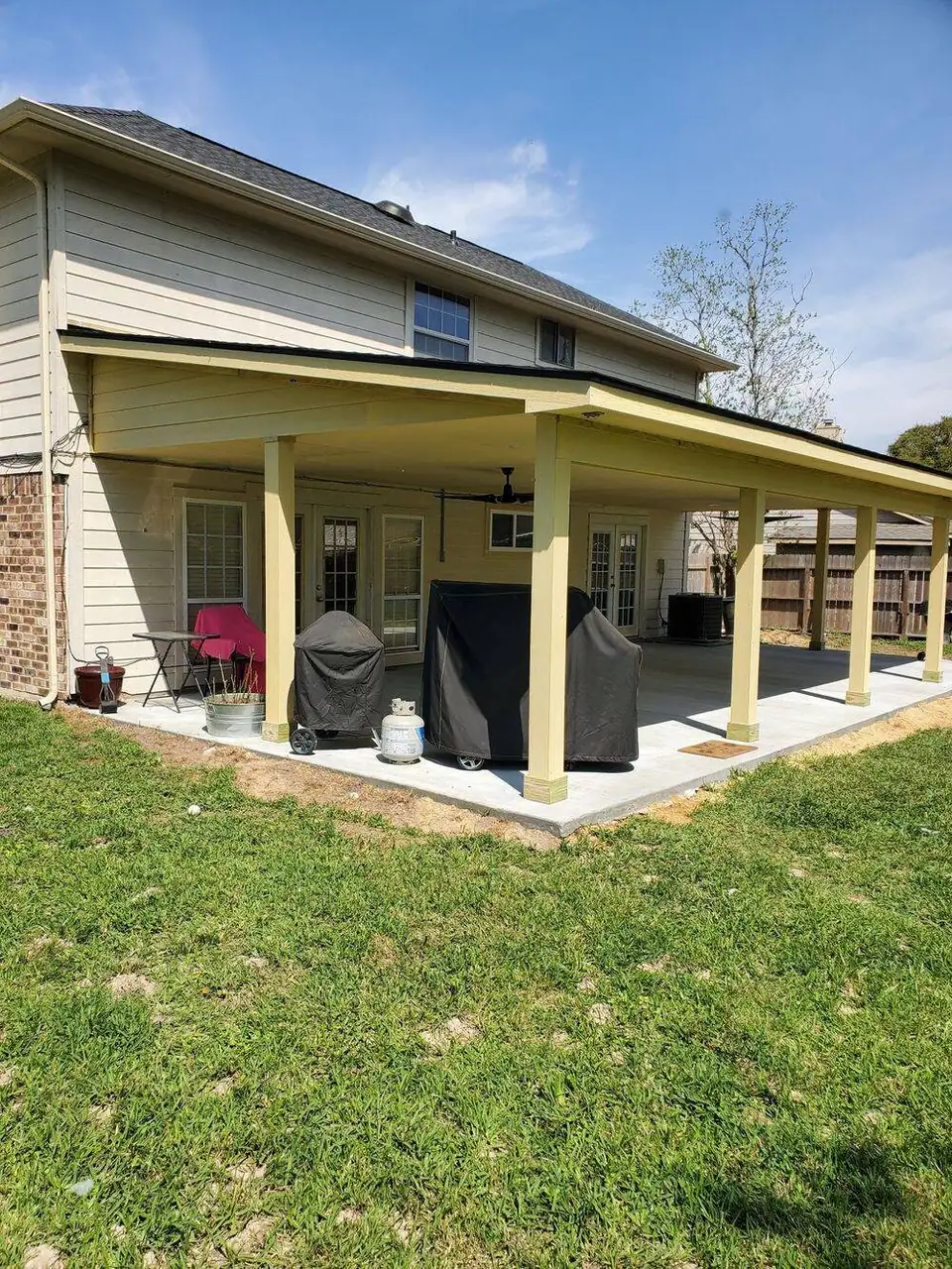 Finished covered patio with ceiling fans and a concrete slab