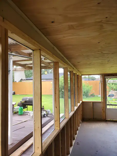 Enclosed patio framed with new windows and a solid roof