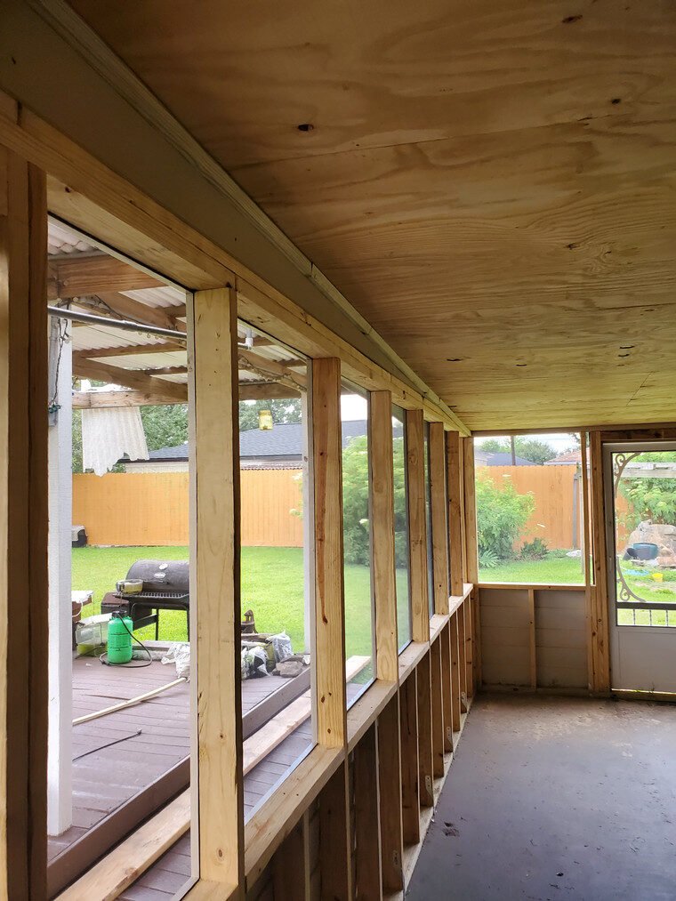 Enclosed patio framed with new windows and a solid roof