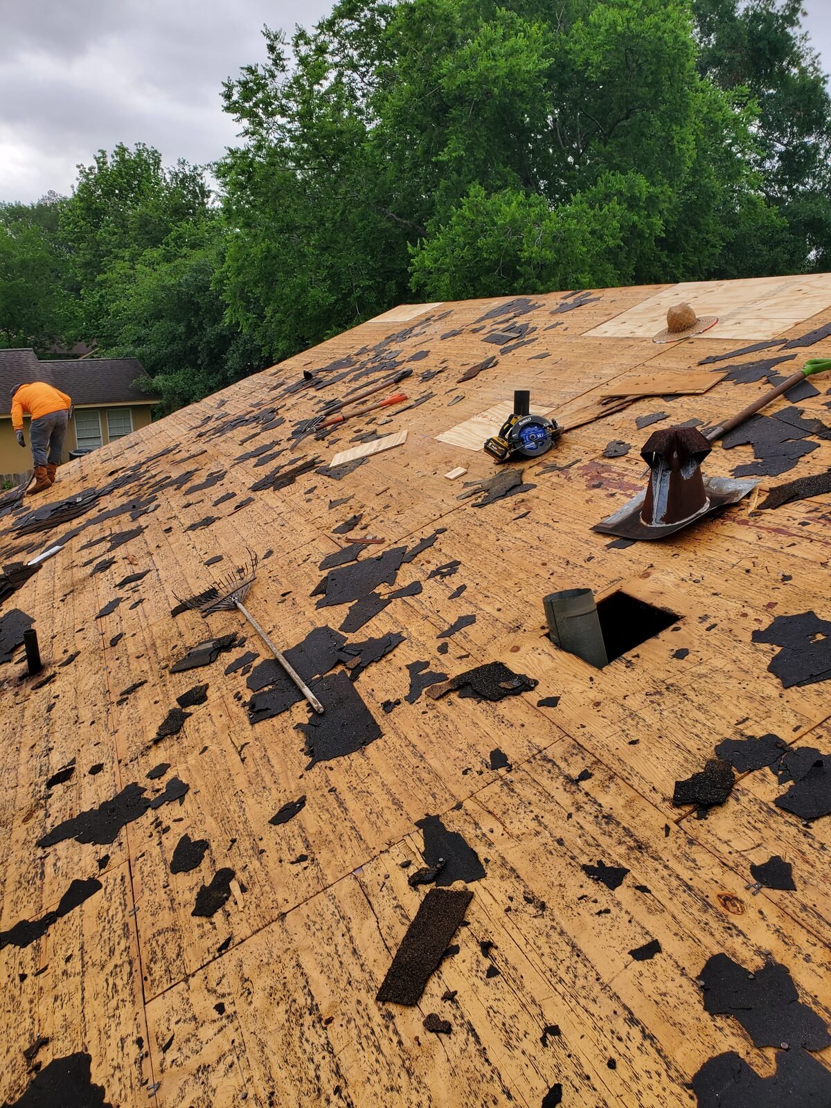 Roof stripped to the decking showing holes and rotted wood before repair