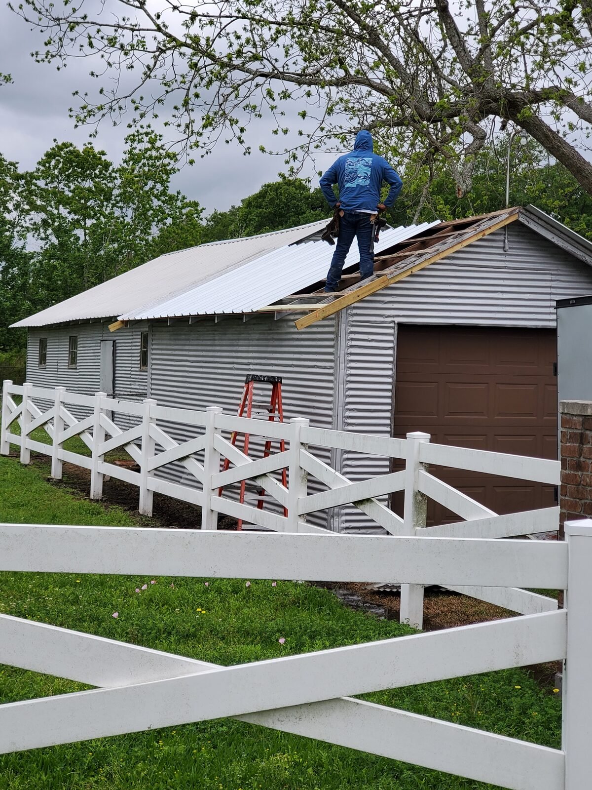 Crew installing a new metal roof on a metal shop building