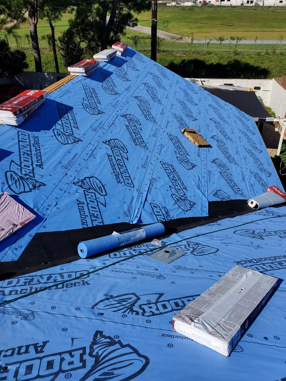 Synthetic underlayment laid across a roof before shingles